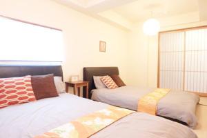 - une chambre avec 2 lits et une fenêtre dans l'établissement Daiki Building 2, à Kyoto