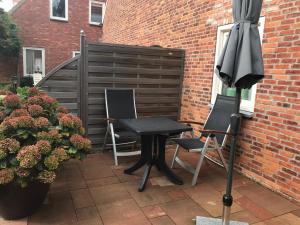 a table and two chairs and an umbrella on a patio at Hendrikhof - appartement 1 ‘de Tas’ in Westkapelle