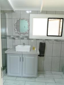 a white bathroom with a sink and a window at Kruger View Tree House in Marloth Park