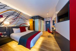 1 dormitorio con 1 cama con una pintura en la pared en Sleeperz Hotel Dundee, en Dundee