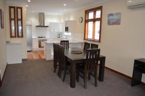 eine Küche mit einem Esstisch und Stühlen in der Unterkunft Villa 185- Central Masterton in Masterton