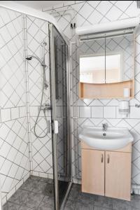 La salle de bains est pourvue d'un lavabo et d'une douche. dans l'établissement Motala Wärdshus, à Motala