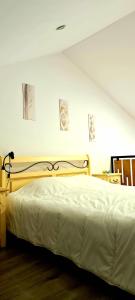 1 dormitorio con 1 cama con colcha blanca en Cattleya's Loft en Veliko Tŭrnovo