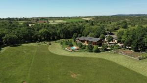 an aerial view of a house on a large green field at Gîte des Conquettes in Salles-la-Source