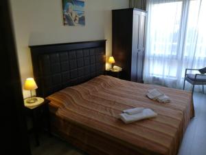a bedroom with a bed with two towels on it at Private Apartments in Royal Beach 5* in Sunny Beach +24 photos