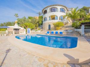 a swimming pool in front of a house at Villa Alondra - Plusholidays in Moraira