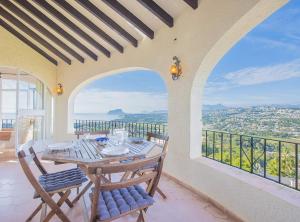 a dining room with a table and chairs on a balcony at Villa Alondra - Plusholidays in Moraira