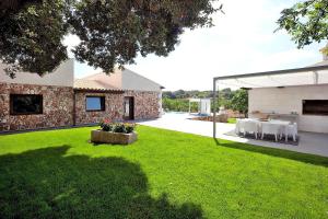 a backyard of a house with a grass yard at Villa Son Calet 156 by Mallorca Charme in Llubí