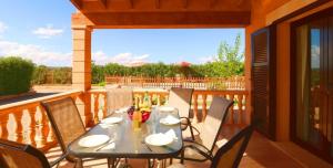 einen Tisch und Stühle auf einem Balkon mit Aussicht in der Unterkunft Finca Can Olivaret 419 by Mallorca Charme in Campos