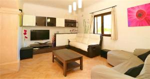 ein Wohnzimmer mit einem Sofa und einem TV in der Unterkunft Finca Can Olivaret 419 by Mallorca Charme in Campos