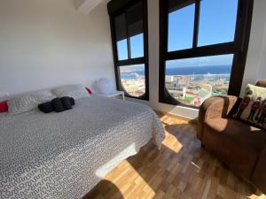 サンタクルス・デ・テネリフェにあるVacacional conceptual vistas mar y centroのベッドルーム1室(ベッド1台、椅子、窓付)
