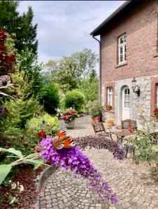 um jardim com flores roxas em frente a um edifício em Haus Bergstrasse em Stolberg