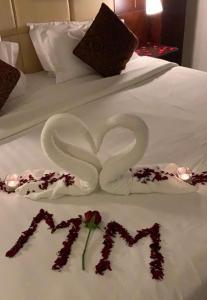 two swans made out of towels on a bed at Sharz Hotel in Buraydah