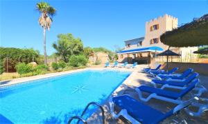 een zwembad met blauwe ligstoelen en een huis bij Finca Can Palea 407 by Mallorca Charme in Campos