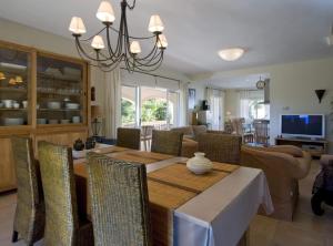 Villa Cumbre - Plusholidays في بينيتاشيل: غرفة طعام وغرفة معيشة مع طاولة وكراسي