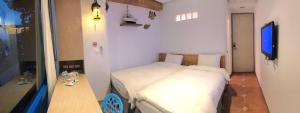 Dormitorio pequeño con cama y mesa en Sun Fog Hotel, en Yuchi