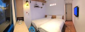 a small bedroom with a bed and a table at Sun Fog Hotel in Yuchi