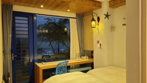 a bedroom with a window and a bed and a desk at Sun Fog Hotel in Yuchi