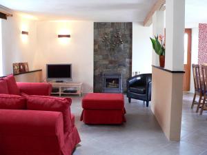 een woonkamer met rode meubels en een open haard bij La Terrasse in Sorèze