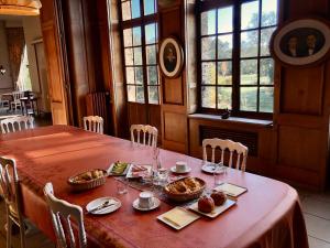 - une table avec de la nourriture dans une chambre avec des fenêtres dans l'établissement Le Logis d'Arniere, à Saint Cyr-sous-Dourdan