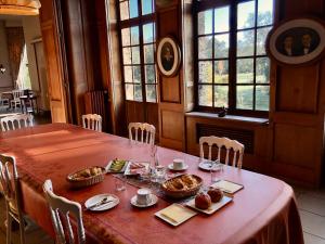 a table with food on it in a room with windows at Le Logis d'Arniere in Saint Cyr-sous-Dourdan
