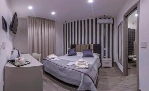 1 dormitorio con 1 cama y baño con lavamanos en Le Origini Rooms&Suite en Cosenza