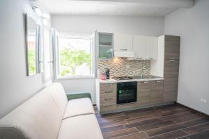 a white kitchen with a couch and a window at Mini Appartamento con giardino in centro in Catanzaro