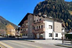 a building on the side of a road with a mountain at Liz Hotel & Apartments in Predazzo