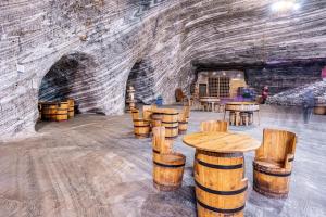 a room with wooden tables and a brick wall at PENSIUNEA LUI CALIN in Ocnele Mari