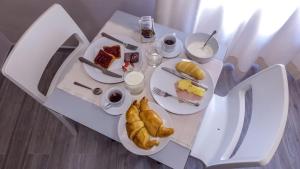 a white table with plates of food on it at Le Origini Rooms&Suite in Cosenza