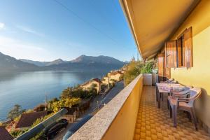 a balcony with tables and chairs and a view of the water at Casa Sofie e Charlotte in Varenna