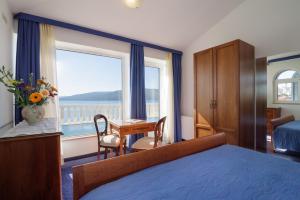a hotel room with a bed and a desk and a window at Villa Mediterana in Seget Vranjica