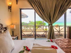 
a hotel room with a large window overlooking the ocean at Jambiani White Sands Bungalows in Jambiani
