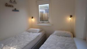Cette petite chambre comprend 2 lits et une fenêtre. dans l'établissement Rekerlanden 267, à Warmenhuizen