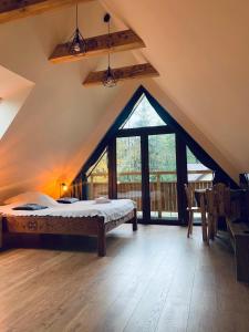 1 dormitorio con cama y ventana grande en Willa Wysoka en Zakopane