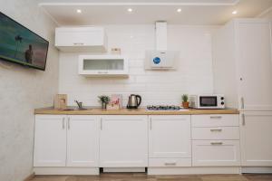 Una cocina con gabinetes blancos y un microondas. en Luxe apart-hotel near Lavina New Building 1 floor, en Sumy 24 fotos más
