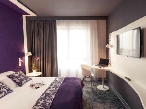 una camera d'albergo con letto e finestra di Mercure La Roche Sur Yon a La Roche-sur-Yon