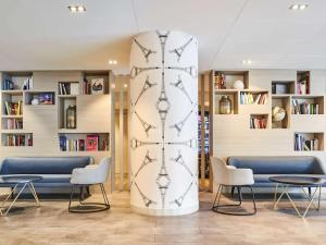 a surfboard in a room with chairs and tables at ibis Paris Porte de Montreuil in Paris