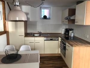 a kitchen with white cabinets and a sink at Platzhirsch Seligenstadt - Im Herzen der Altstadt in Seligenstadt