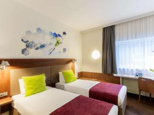 Habitación de hotel con 2 camas y ventana en Ibis Styles Vilnius en Vilna