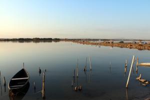 a boat sitting in the water next to a dock at Studio 237 Port Camargue, Piscine, Climatisation, 2 personnes in Le Grau-du-Roi