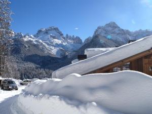 a pile of snow on a house with a snowboard at Fogajard Lovely Chalet in Madonna di Campiglio
