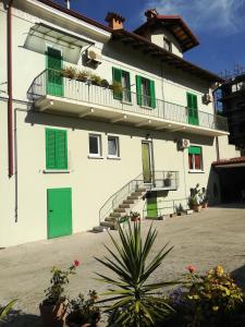 Edificio blanco con persianas verdes y balcón en Gorizia vacanze, en Gorizia