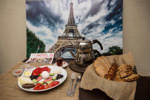 una mesa con un plato de comida frente a la torre Eiffel en HOTEL 22, en Edirne