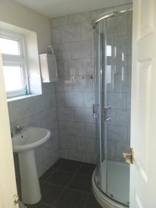 a bathroom with a shower and a sink at Large double room or single room with shared bathroom in Ash