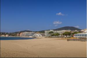 a sandy beach with buildings in the background at Appartement Anna Grande Vue Mer in Sainte-Maxime