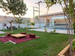 a backyard with a picnic table in the grass at شاليه الفورسيزونز in Buraydah