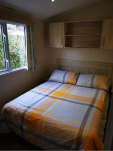 a bed in a small room with a window at 67 Newquay Getaway in Porth