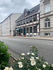 un edificio al lado de una calle con flores en Pension Karina Schwerin en Schwerin