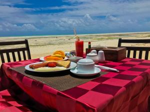 a table topped with plates of food on top of a beach at Jambiani White Sands Bungalows in Jambiani